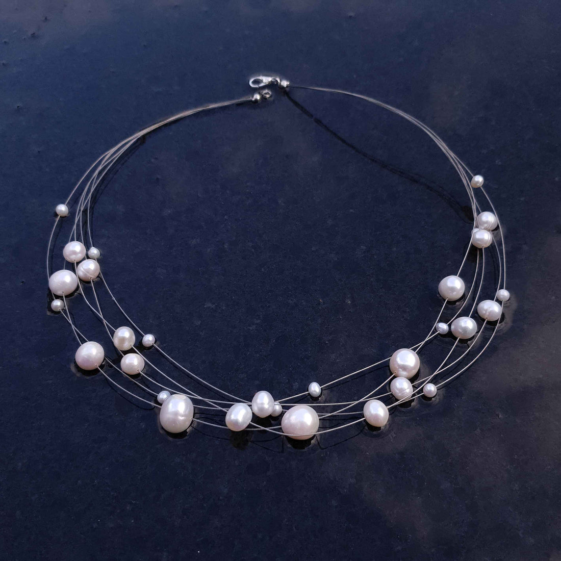 Zoetwater parelketting met witte parels en sterling zilver in 5 rijen liggend op leisteen| Avetta