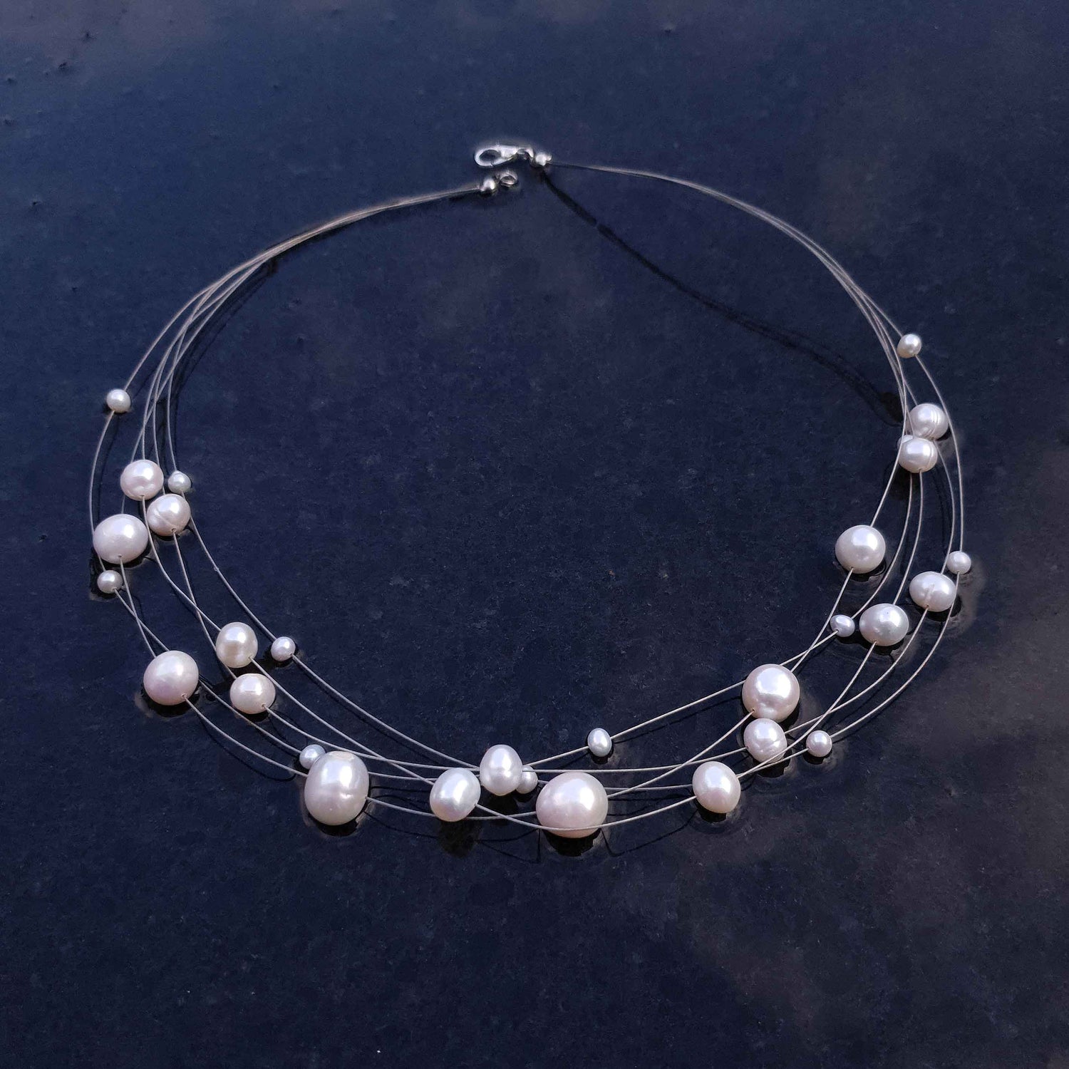 Zoetwater parelketting met witte parels en sterling zilver in 5 rijen liggend op leisteen| Avetta