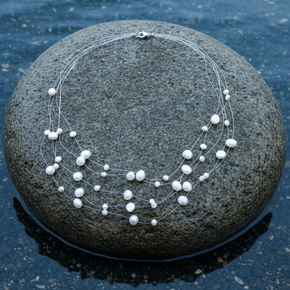 Zoetwater parelketting met witte parels in 5 rijen en sterling zilver (925) liggend op steen in water | Gill W
