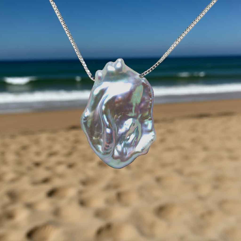 Grijze parelketting met achtergrond strand en zee | Gina