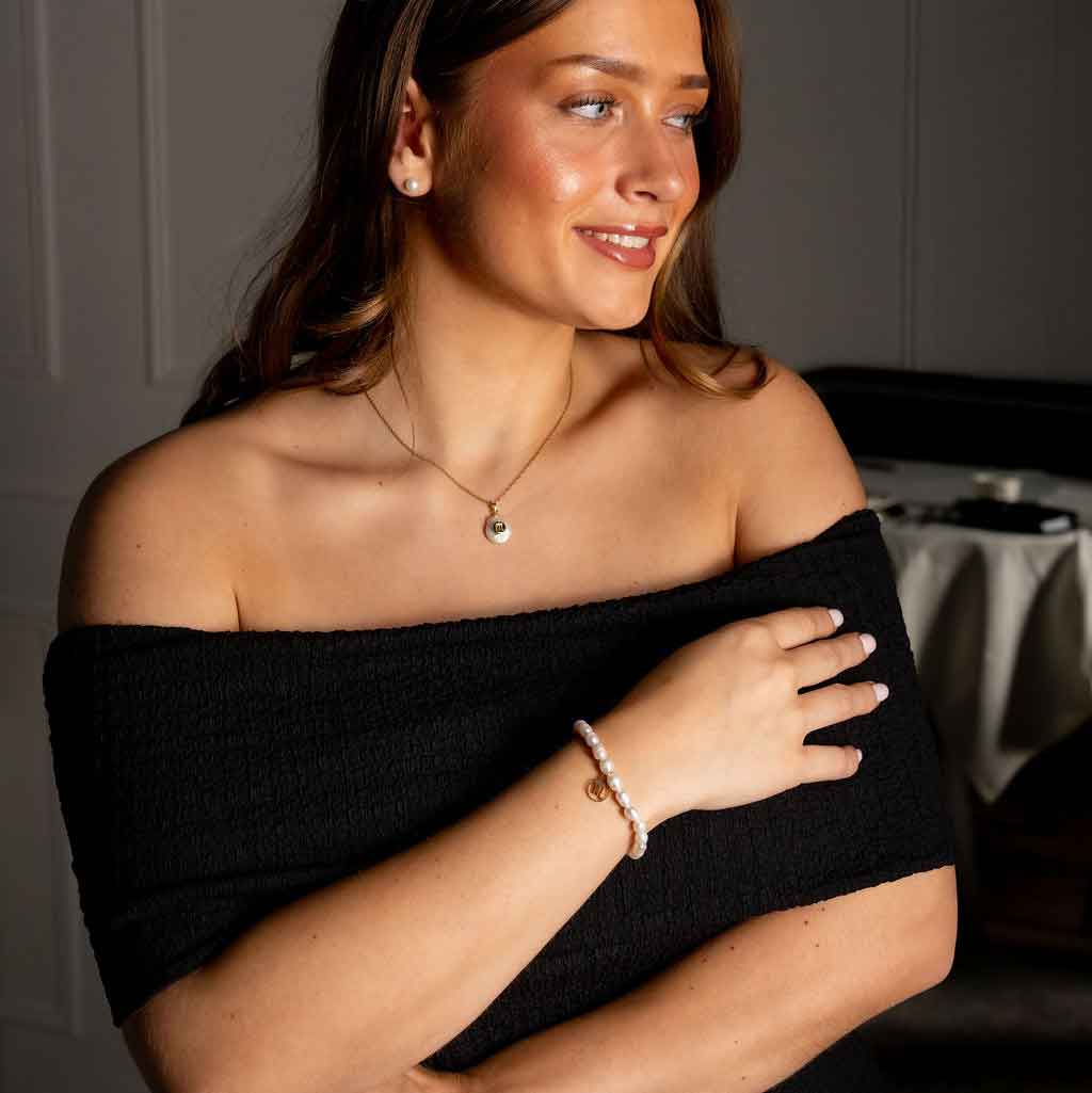 Zoetwater parelketting met witte parel hanger met gouden symbool van sterrenbeeld schorpioen en goud edelstaal op model met jurk | Gouden Sterrenbeeld Schorpioen