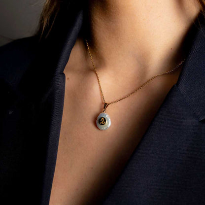 Detail van zoetwater parelketting met witte parel hanger met gouden symbool van sterrenbeeld steenbok en goud edelstaal op model detail | Gouden Sterrenbeeld Steenbok