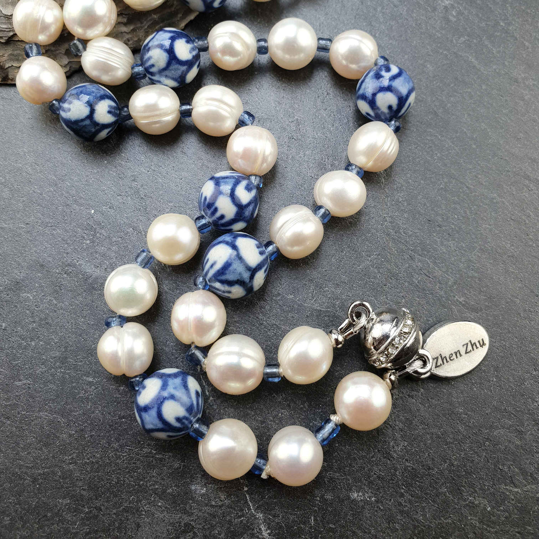 Zoetwater parelketting met witte parels, kralen met Delfts blauw motief en magneetslotje liggend op leisteen | Hollands Glorie Round Flower White