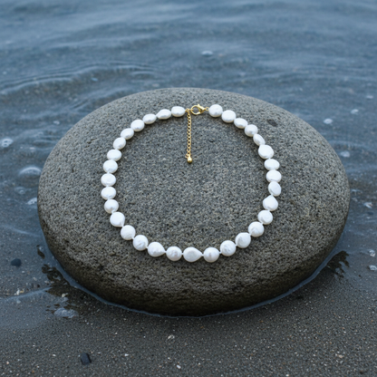 Witte zoetwater parelketting met coin parels en goud edelstaal liggend op steen | Little Coin Pearl
