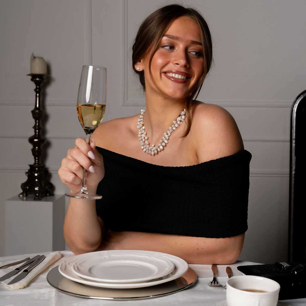 Zoetwater parelketting met witte parels in 3 rijen op model aan tafel | Phebe