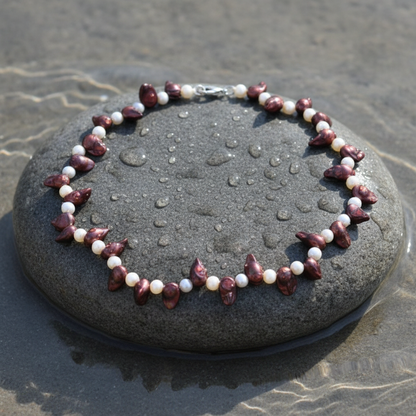 Zoetwater parelketting met witte en rood bruine parels en sterling zilveren slotje liggend op steen in water | Purple Lady