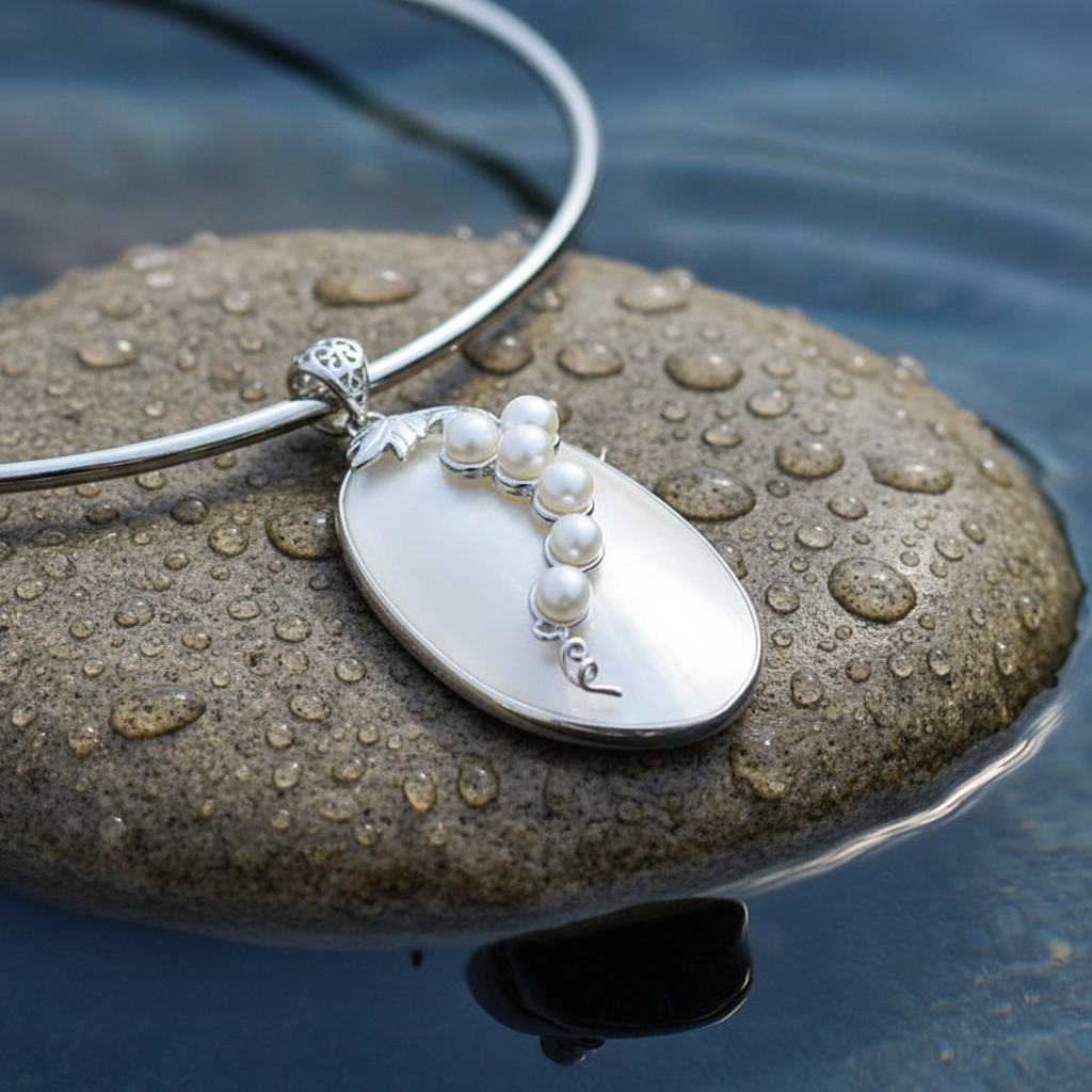 Korte zoetwater parelketting met witte parels en een witte schelp liggend op natte steen close up | Shell Pearl Grape