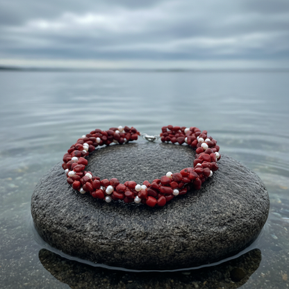 Zoetwater parelketting met witte parels en rood koraal in 5 rijen liggend op steen in water | Caro
