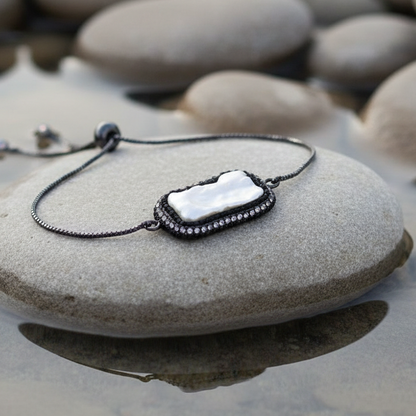 Wit zoetwater parel armband met stras steentjes en schuifsluiting liggend op steen in water | Black Bright Biwa Pearl