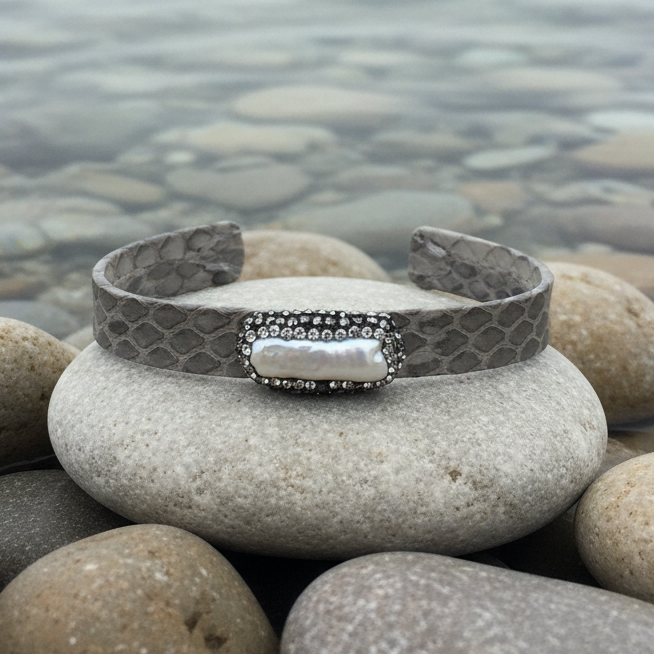 Wit zoetwater parel armband met stras steentjes en grijs leer liggend op steen aan waterrand | Bright Biwa Pearl Grey Leather
