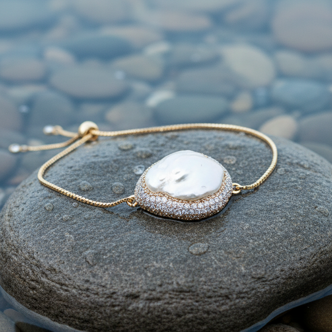 Wit zoetwater parel armband met grote witte parel en stras steentjes liggend op steen in water | Bright Golden Fireball