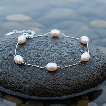Zoetwater parel armband met zalm roze parels liggend op natte steen | Pearl Chain Peach