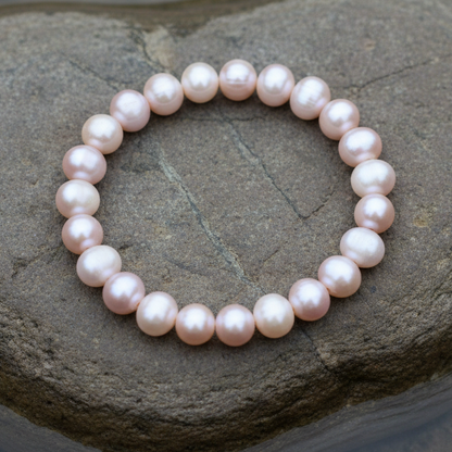 Roze zoetwaterparel armband liggend op steen, elastisch | Round Pink