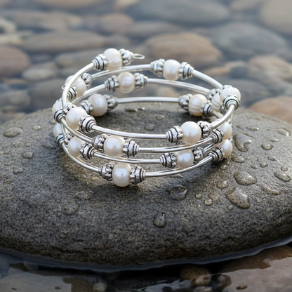Wit zoetwater parel wikkelarmband liggend op steen in water | Three Loops White Pearlarmband