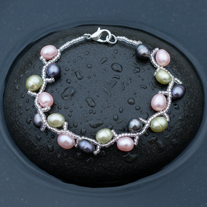Zoetwater parel armband met roze, lime groen en grijze parels liggend op steen in water | Twist Pearl Mix Color