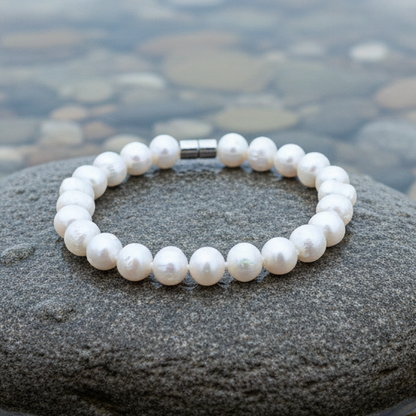Wit handgeknoopt zoetwater parel armband met magneetslot liggend op natte steen | Walla Two