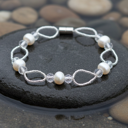 Wicio parel armband close-up op grijze natte steen bij oever