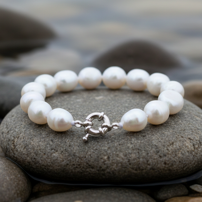 Witte handgeknoopte zoetwater parel armband liggend op steen aan waterrand | Wola Two