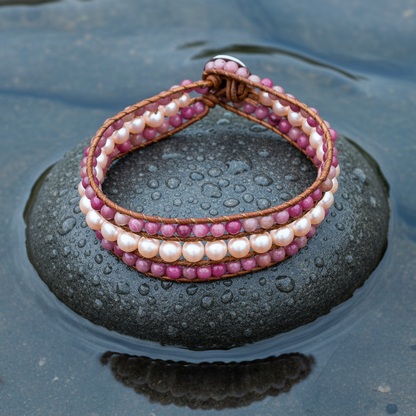 Zoetwater parel armband met rhodochrosiet en zalm kleurige parels liggend op steen in water | Parel armband Kallie