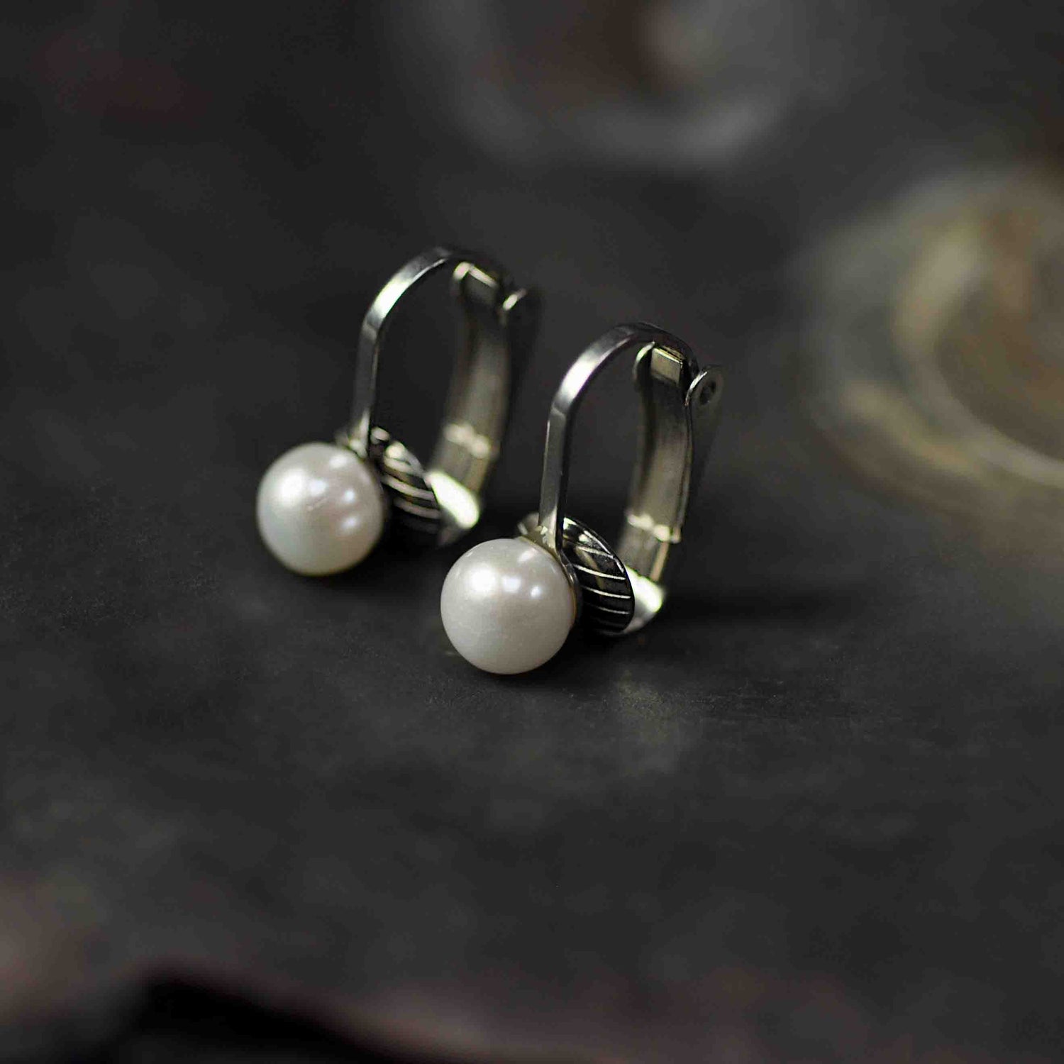 Kleine witte zoetwater parel clips oorbellen met edelstaal staand in schelp | Fiell Clip Pearl Small