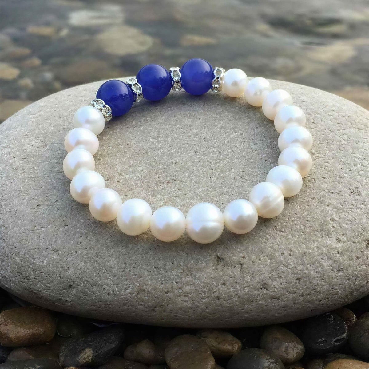 Wit zoetwater parel armband met blauwe jade en stras steentjes liggend op steen achteraanzicht, elastisch | Pearl Blue Jade