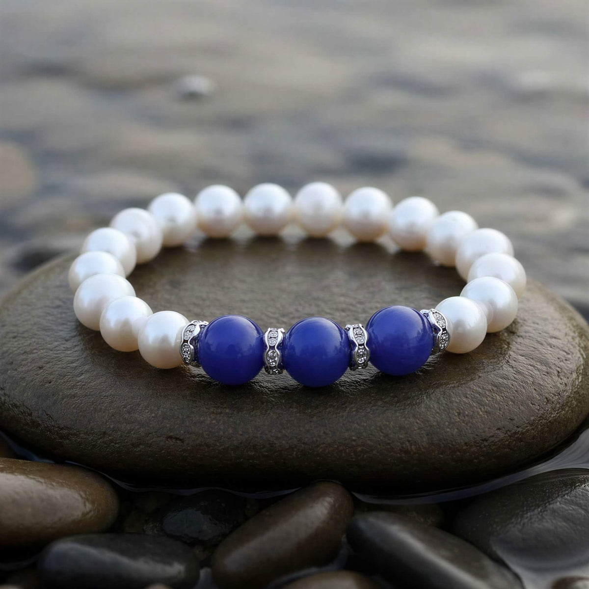 Wit zoetwater parel armband met blauwe jade en stras steentjes liggend op steen vooraanzicht, elastisch | Pearl Blue Jade
