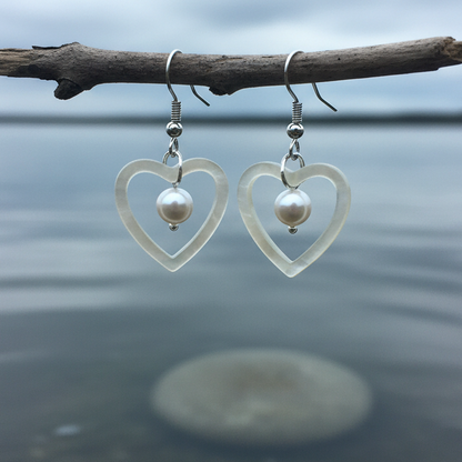 Parel en parelmoer hart oorbellen hangend aan takje