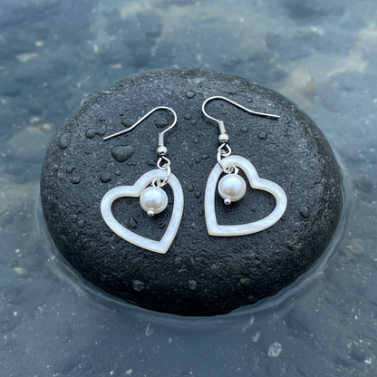 Parel en parelmoer hart oorbellen op natte steen