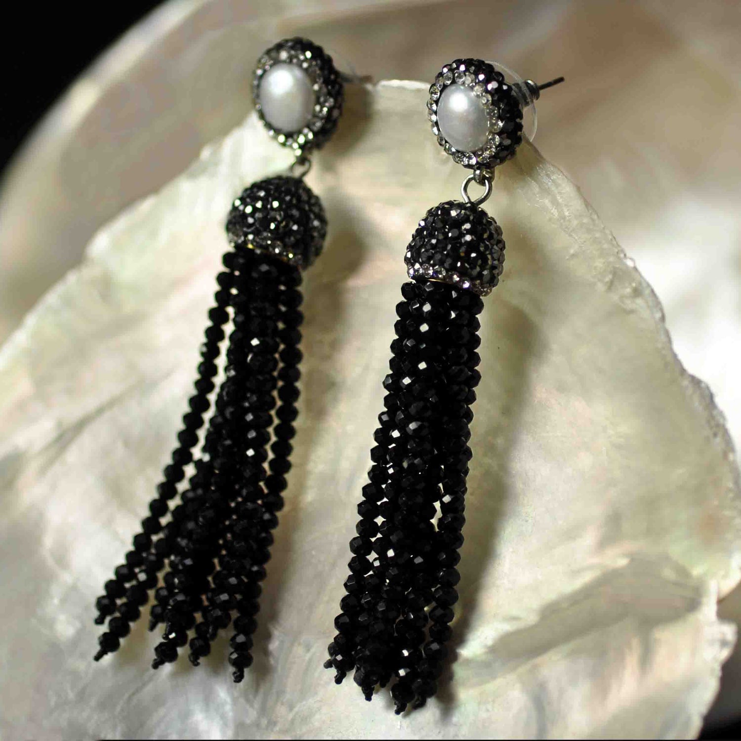 Lange zoetwater parel oorbellen met witte parel en zwart kristallen kwastje hangend aan schelp zijaanzicht| Bright Pearl Black Crystal Tassel