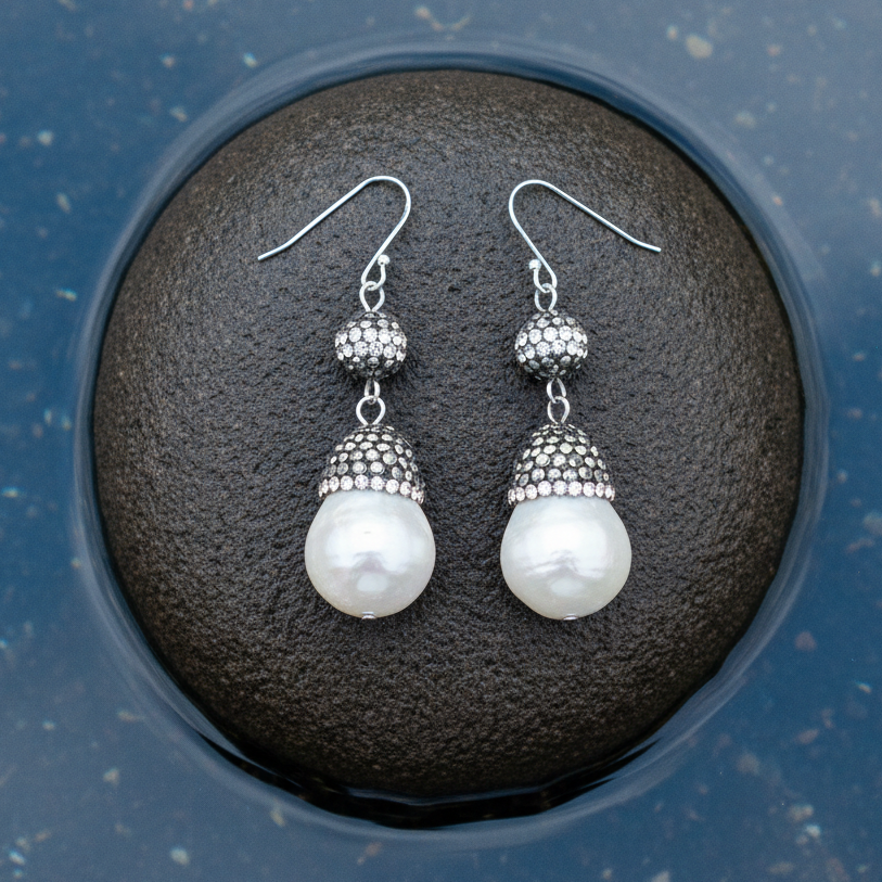 Witte parel oorbellen met stras steentjes en sterling zilver (925) liggend op steen |  Bright Paerl Dangling Nut