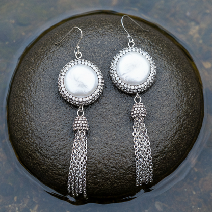 Lange witte zoetwater parel oorbellen met sterling zilver (925), stras steentjes en kwastje liggend op steen| Bright Pearl Dangling Tassel