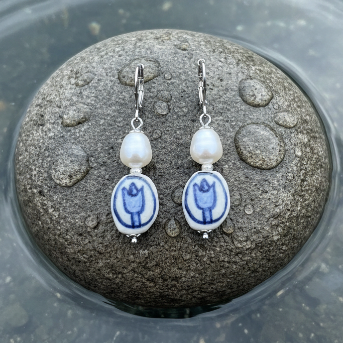 Zoetwater parel oorbellen met witte parels, Delfts blauw ornament en edelstaal liggend op steen in water | Hollands Glorie Tulp Wit