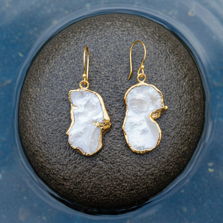Witte zoetwater parel oorbellen met keshi parels en goud edelstaal liggend op steen | Long Keshi Pearl