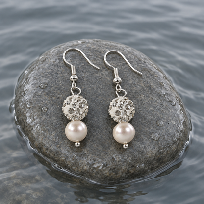 Witte zoetwater parel oorbellen met stras bal en sterling zilver (925) liggend op steen in water | Maxima