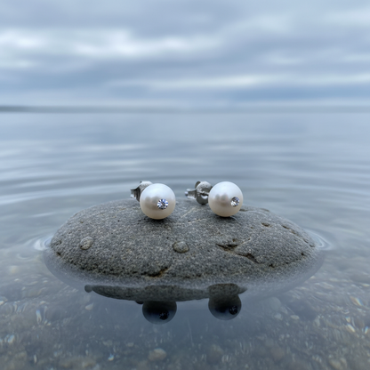 Witte zoetwater parel oorbellen met stras steentje, parel oorknopje liggend op steen in water vooraanzicht | Mea Bling Small White