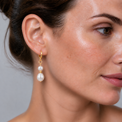 Witte zoetwater parel oorbellen met gouden edelstalen oorringen op model | Paulette