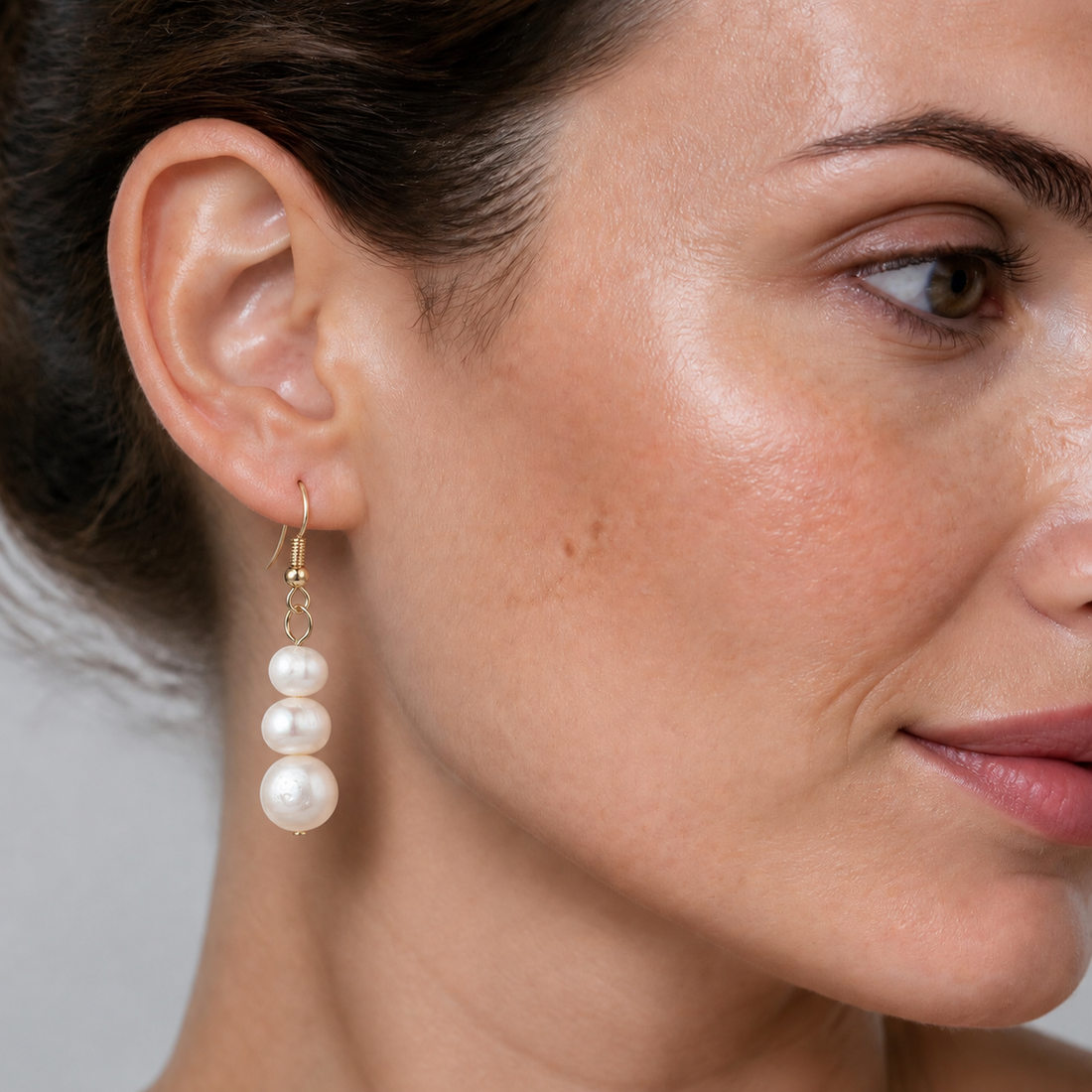 Witte zoetwaterparel oorbellen met goud edelstaal op model | Paulien