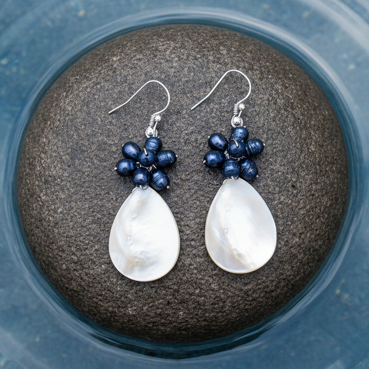 Zoetwater parel oorbellen met blauwe parels, wit parelmoer en sterling zilver (925) liggend op steen | Purssian Blue Pearl White Shell