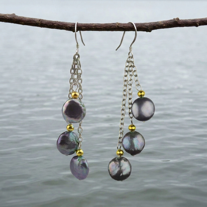 Lange zoetwater parel oorbellen met paars blauwe parels en sterling zilver (925) hangend aan takje boven water | Vivienne