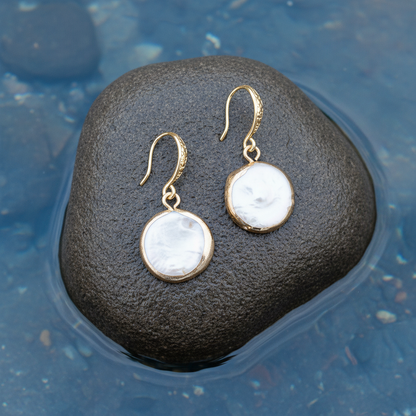 Witte zoetwater parel oorbellen liggend op steen | White Coin Pearl Gold Small