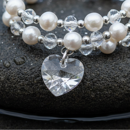 Wit zoetwater parel wikkel armband met kristallen hartje liggend op steen close up | Wrap Pearl Crystal Heart