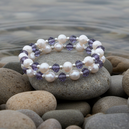 Zoetwater parel wikkel armband met witte parels en paarse glas kristallen liggend op steen aan waterrand | Wrap Pearl Purple Crystal