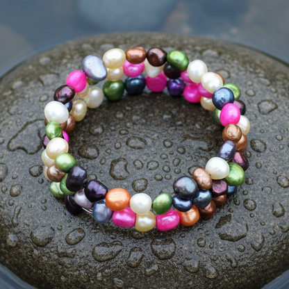 Kleurrijke parel armband op natte grijze steen bovenaanzicht | Zen Colorful
