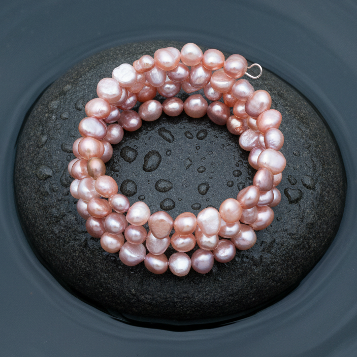 Zoetwater parel wikkel armband met roze parels liggend op steen in water | Zen Rose
