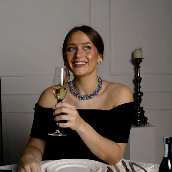 Blauw grijze zoetwater parelketting bestaande uit 3 rijen parels op model aan tafel | Amina