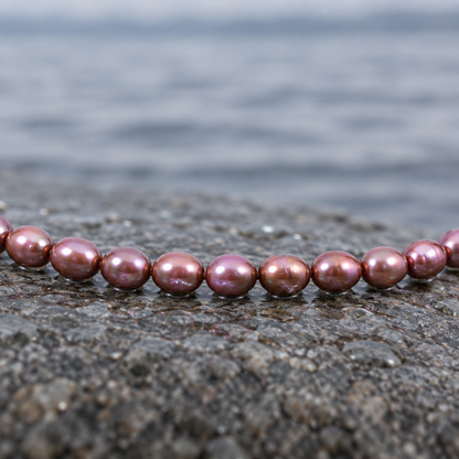 Bruine zoetwater parelketting met sterling zilver (925) liggend op steen in water close up | Bini