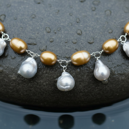 Zoetwater parelketting met grijze, bruine en gouden parels en sterling zilver (925) liggend op steen in water close up | Daisy