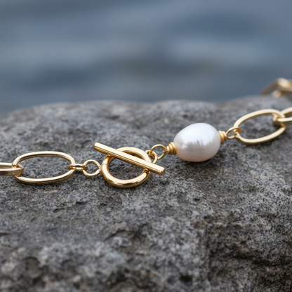 Detail van witte zoetwater parelketting met goud aluminium en barok parels liggend op steen | Gold Paperclip Pearl