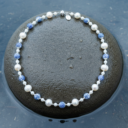 Zoetwater parelketting met kralen met Delfts blauw motief en magneetslotje liggend op steen | Hollands Glorie Zilver Bling