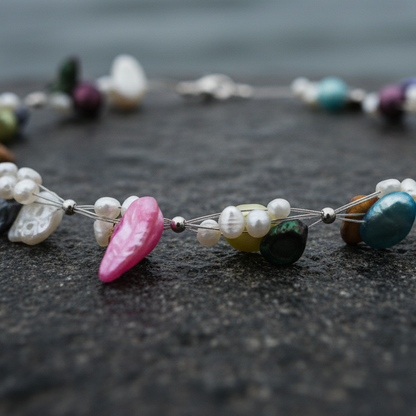 Zoetwater parelketting met vrolijk gekleurde parels en sterling zilver (925) liggend op steen close up | Olivia